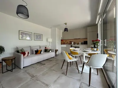 a living room with a couch and a table and chairs at L'Oasis Maritime By Avecoeur in Nice