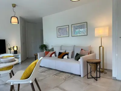 a living room with a white couch and a table at L'Oasis Maritime By Avecoeur in Nice