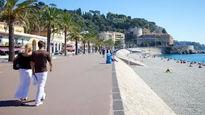 a man and a woman walking down a beach at Jazzy et Spacieux Appartement Prom des Anglais in Nice