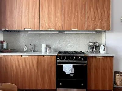 a kitchen with a black stove and wooden cabinets at Blue House in Villefranche-sur-Mer