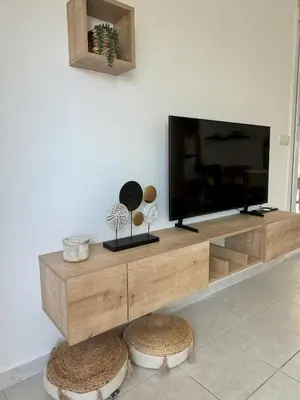 a flat screen tv sitting on top of a wooden entertainment center at Elegant Apartment with Sea View and Swimming pool in Nice