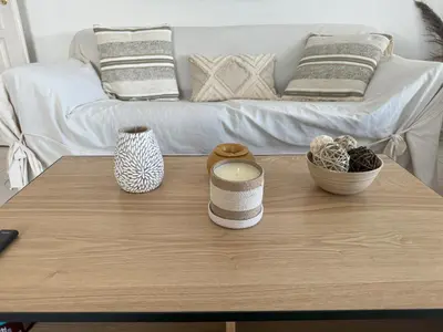 a coffee table with two vases and a candle on it at Elegant Apartment with Sea View and Swimming pool in Nice