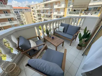 a balcony with chairs and a table on a building at Elegant Apartment with Sea View and Swimming pool in Nice