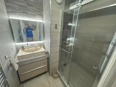 a man taking a picture of a bathroom with a shower at Elegant Apartment with Sea View and Swimming pool in Nice