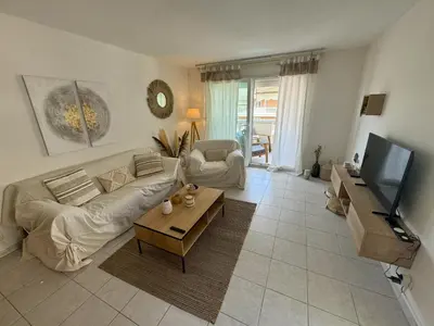a living room with a couch and a tv at Elegant Apartment with Sea View and Swimming pool in Nice