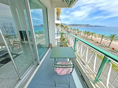 a balcony with a table and a view of the beach at Milord Promenade 4 in Nice