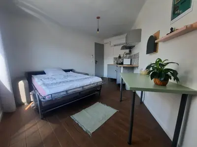 a bedroom with a bed and a green table at La Chambre 3, Climatisée AC, Cuisine privée, Calme in Nice