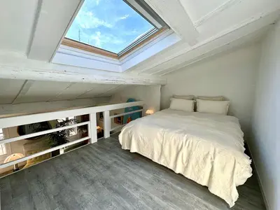 a bedroom with a large bed with a skylight at Superbe duplex entre le Vieux Nice et la Prom in Nice