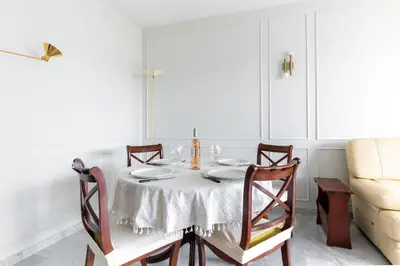 a white dining room with a table and chairs at Happyfew Le Floreal in Nice