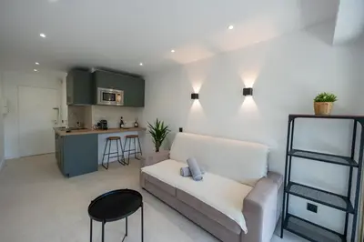 a living room with a couch and a kitchen at Studio idéalement situé résidence front de mer in Saint-Laurent-du-Var