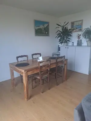 a wooden dining room table with chairs and a kitchen at La bella vista in Nice