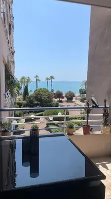 a view of a balcony with a reflection in the water at face à la mer in Cros-de-Cagnes