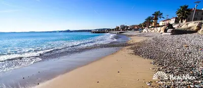 a beach with a rocky shoreline and the ocean at face à la mer in Cros-de-Cagnes