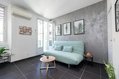 a living room with a blue couch and a table at Large & Quiet 1 Bdr at Nice Port in Nice