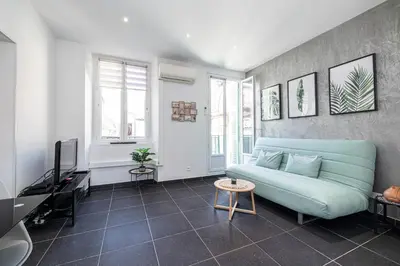 a living room with a blue couch and a tv at Large & Quiet 1 Bdr at Nice Port in Nice