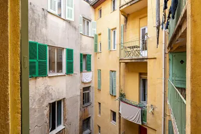an alley of an apartment building with green shutters at 2 Bdr Heart of the Old Town in Nice