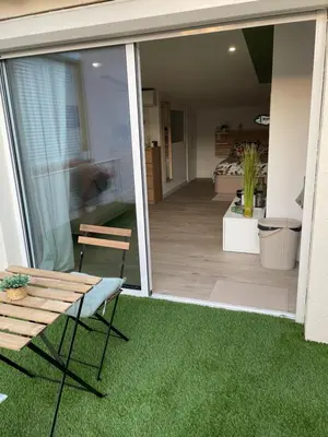 a patio with a table and a bench on the grass at La chambre de Cleron in Saint-Laurent-du-Var