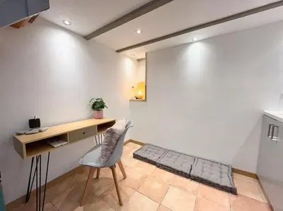 a room with a desk and a chair and a table at Maison Belle Vue & Jardin- Tout à proximité à Pied in Gattières