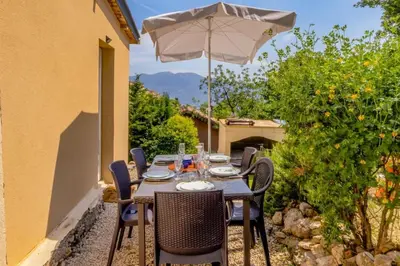 a table and chairs with an umbrella on a patio at Maison Belle Vue & Jardin- Tout à proximité à Pied in Gattières