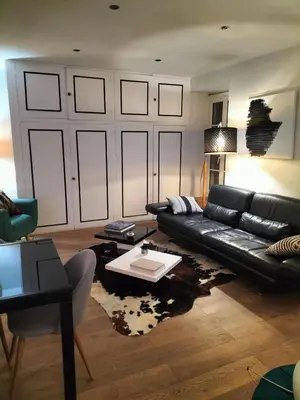 a living room with a black leather couch and a table at Movida in Nice