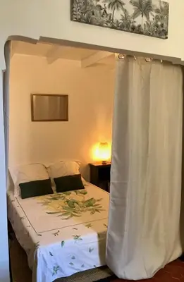 a bed with a canopy in a bedroom at Petit cocon in Villefranche-sur-Mer