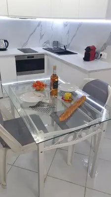 a glass table with a bottle of alcohol and food on it at Central place close to the beach AC air , WI FI, parking in Nice