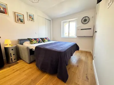 a bedroom with a bed and a clock on the wall at APartHotel Riviera - COCON DE LA LIBERTE - Grimaldi - Promenade des Anglais in Nice
