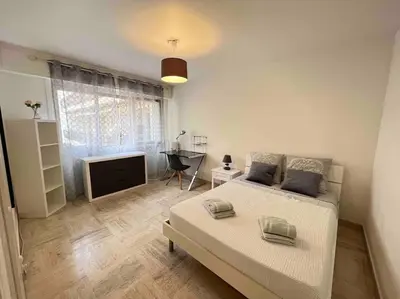 a white bedroom with a bed and a television at Superbe 3 pièces près du Port de Nice in Nice
