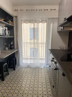 a kitchen with a large window and a tile floor at Superbe 3 pièces près du Port de Nice in Nice