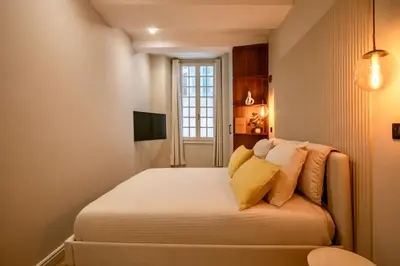 a small bedroom with a bed with yellow pillows at Nice Mer & Cours Saleya Serenity Luxury - 2 suites in Nice
