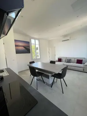 a living room with a table and chairs and a couch at Cosy flat 250m from beach in Nice