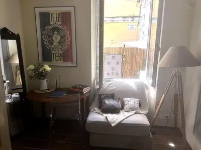 a room with a chair and a table and a mirror at Chez Yaya in Nice
