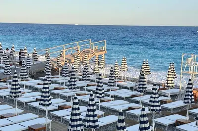 a group of umbrellas on a beach with the ocean at Chez Yaya in Nice