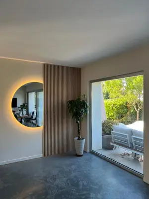 a living room with a potted plant and a mirror at Superbe villa piscine proche ville et mer au calme in Nice