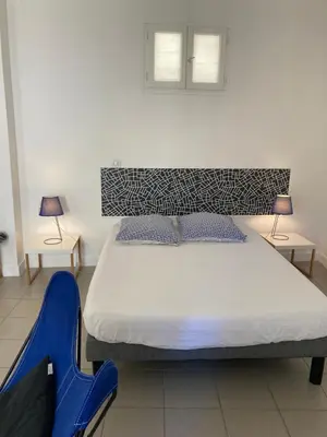 a bedroom with a bed and two tables and two lamps at L'Appartement Bleu in Nice