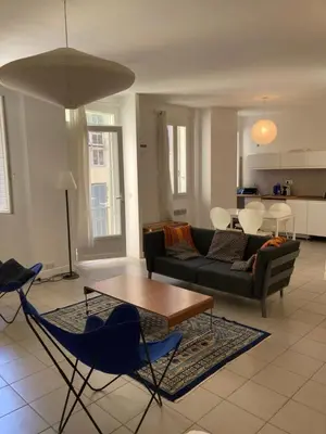 a living room with a couch and a table and chairs at L'Appartement Bleu in Nice