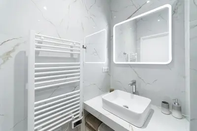 a white bathroom with a toilet and a sink at French riviera old town heart in Nice