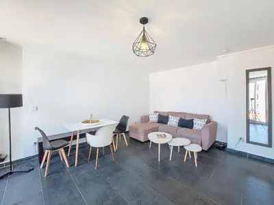 a living room with a couch and a table and chairs at Nestor&Jeeves - GIOFFREDO BELLO - central - near beach in Nice