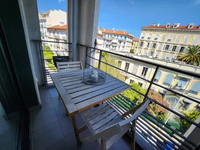 a wooden table on a balcony with a view of a city at Appartement Nice Carré d Or in Nice