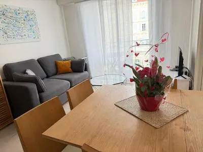 a living room with a table with a vase of flowers on it at Appartement Nice Carré d Or in Nice