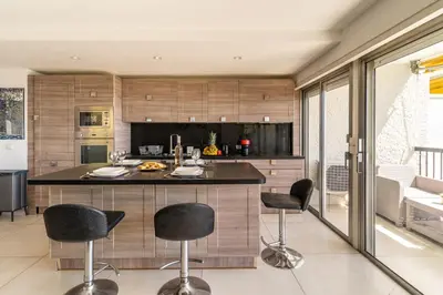 a kitchen with a island with black bar stools at Magnificent 3 Rooms-Sea View-Terrace-Pool in Nice