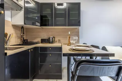 a kitchen with black cabinets and a table with wine glasses at Casa feracci in Villefranche-sur-Mer