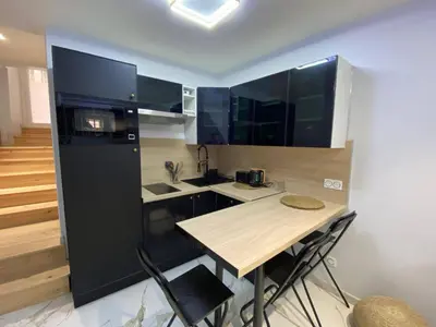 a small kitchen with a table and a black refrigerator at Casa feracci in Villefranche-sur-Mer