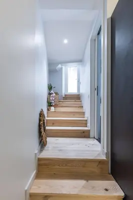 a hallway with wooden stairs in a house at Casa feracci in Villefranche-sur-Mer