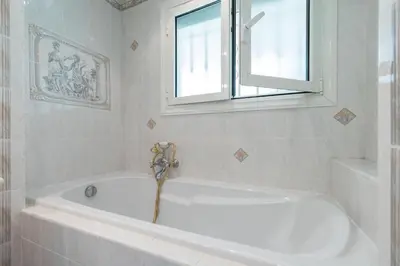 a white bath tub in a bathroom with a window at 2 PIECEs BALCON VUE IMPRENABLE MER---VILLE---MONTAGNE in Nice