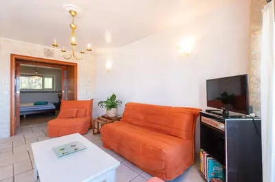 a living room with an orange couch and a tv at 2 PIECEs BALCON VUE IMPRENABLE MER---VILLE---MONTAGNE in Nice