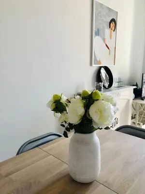 a vase filled with white flowers sitting on a table at Suite Offenbach FSHH in Nice