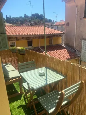 a table and chairs on a balcony with a fence at Historic Bright and Beautiful Apartment in Old Nice with Castle Hill View in Nice