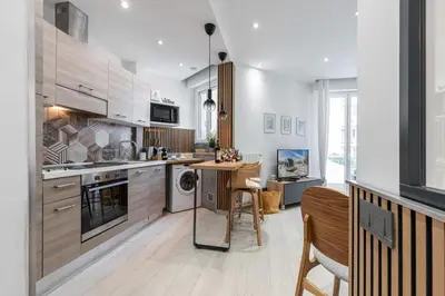 a kitchen with wooden cabinets and a table in it at MY CASA - SMOLETT - Superb Studio Suite Downtown w AC in Nice