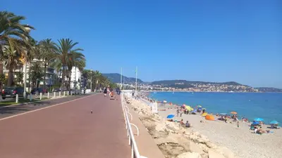 a beach with people on the sand and the water at Very Nice Apartment in Nice